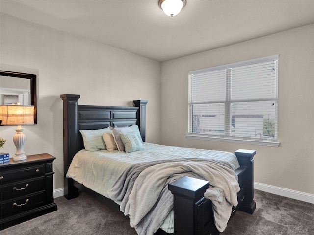 bedroom with dark carpet and baseboards