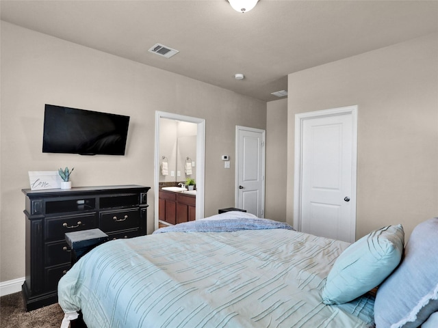 bedroom with carpet flooring, a sink, visible vents, baseboards, and ensuite bath