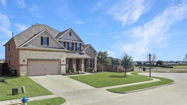 craftsman-style home featuring a garage, fence, driveway, a front lawn, and board and batten siding