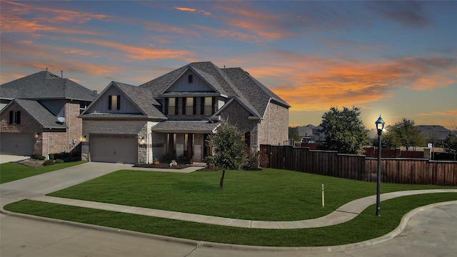 view of front of home with a yard, roof with shingles, fence, and driveway