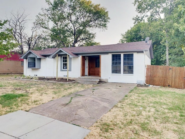 ranch-style home with fence and a front lawn