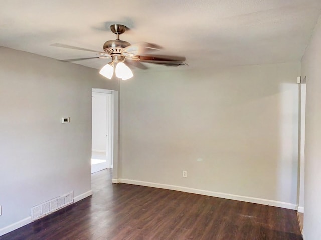 unfurnished room featuring dark wood-style floors, a ceiling fan, visible vents, and baseboards