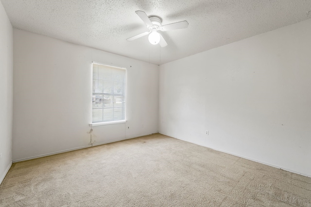 carpeted empty room featuring a textured ceiling and a ceiling fan