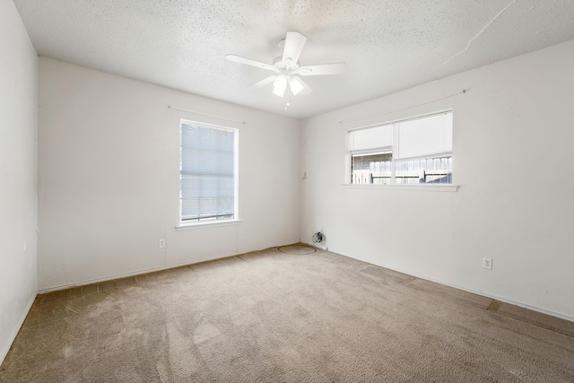 carpeted empty room featuring a textured ceiling and ceiling fan