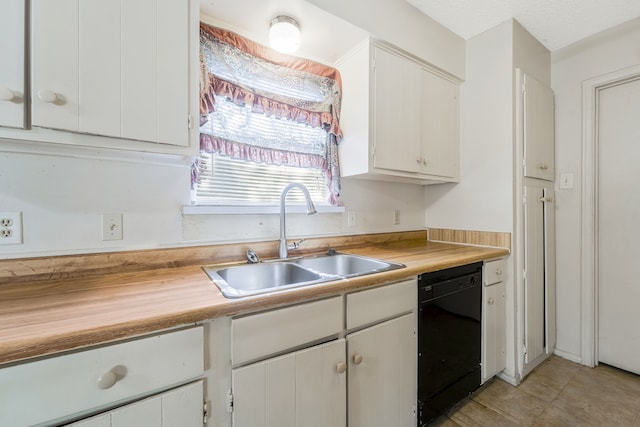 kitchen featuring dishwasher, butcher block counters, a sink, and white cabinets