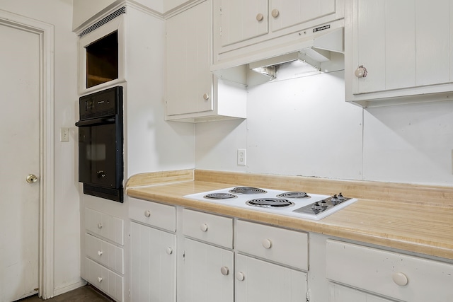 kitchen with white cabinets, white electric cooktop, oven, light countertops, and under cabinet range hood