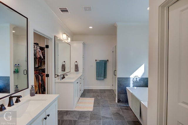 full bath with two vanities, visible vents, ornamental molding, a sink, and a bath