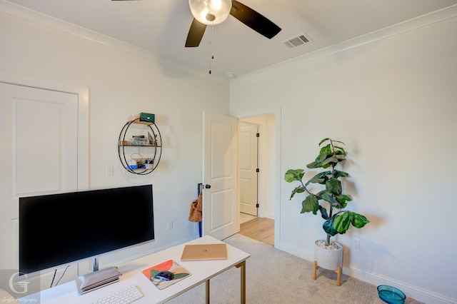 living area featuring light colored carpet, visible vents, baseboards, a ceiling fan, and ornamental molding