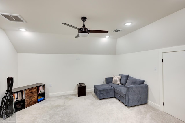 sitting room featuring lofted ceiling, visible vents, and light carpet