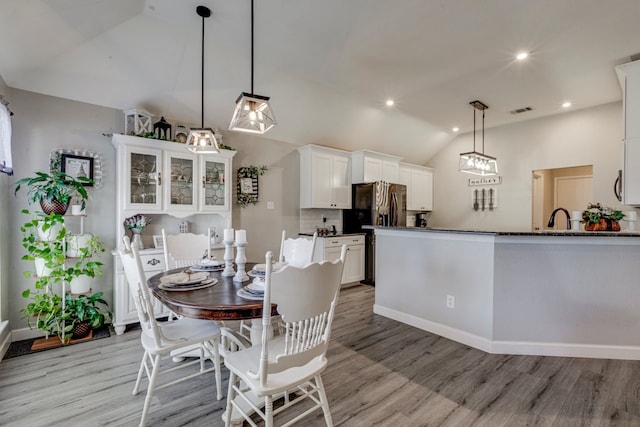 dining space with recessed lighting, visible vents, vaulted ceiling, and light wood-style flooring