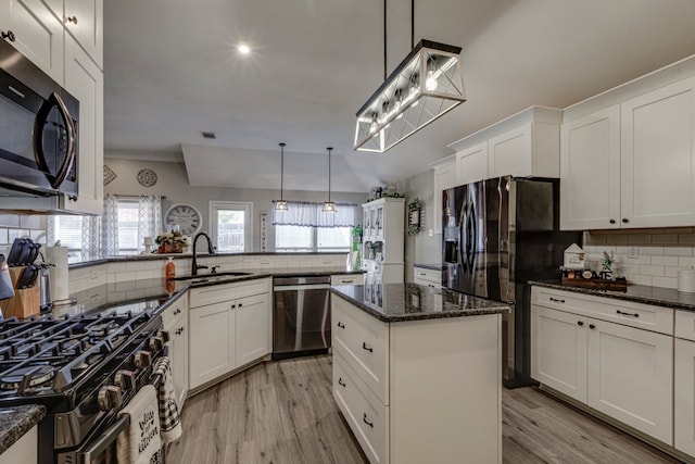 kitchen featuring stainless steel appliances, a sink, light wood-style flooring, and tasteful backsplash