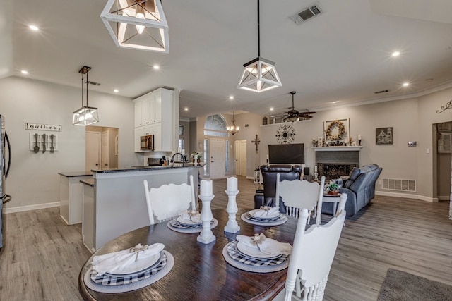 dining area with light wood-type flooring, visible vents, a fireplace, and recessed lighting