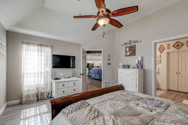 bedroom with visible vents, ceiling fan, vaulted ceiling, wood finished floors, and baseboards