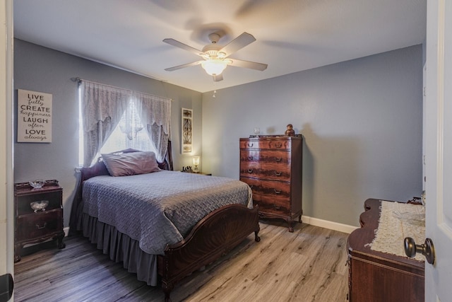 bedroom with light wood-type flooring, baseboards, and a ceiling fan