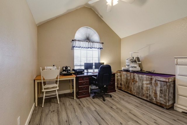 office area featuring light wood-style floors, baseboards, vaulted ceiling, and a ceiling fan