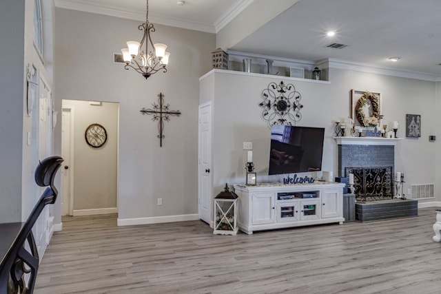 living area featuring a fireplace, visible vents, ornamental molding, light wood-style floors, and baseboards