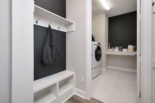 clothes washing area featuring light tile patterned floors, laundry area, visible vents, baseboards, and washer / dryer