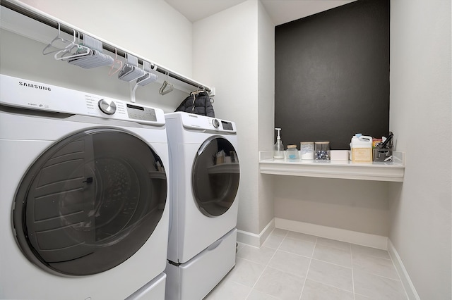 laundry area with laundry area, light tile patterned floors, baseboards, and washer and clothes dryer