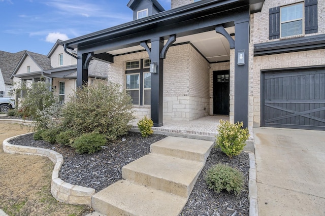 entrance to property with a garage, stone siding, and brick siding