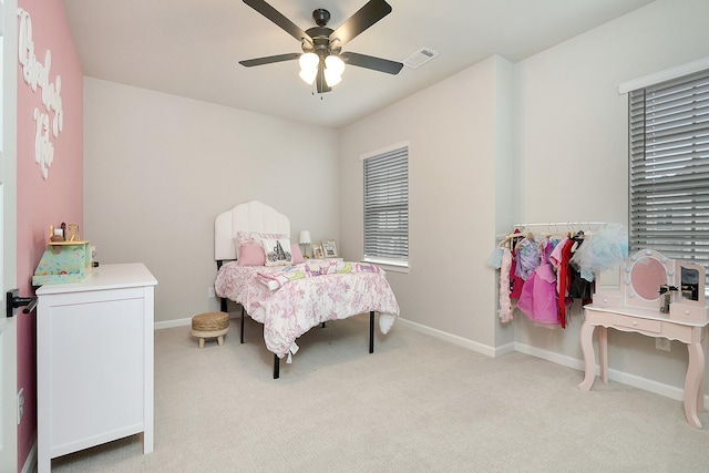 bedroom featuring a ceiling fan, light colored carpet, visible vents, and baseboards