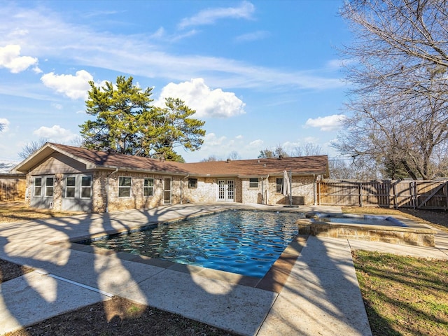 view of swimming pool featuring fence, french doors, a gate, a fenced in pool, and a patio area