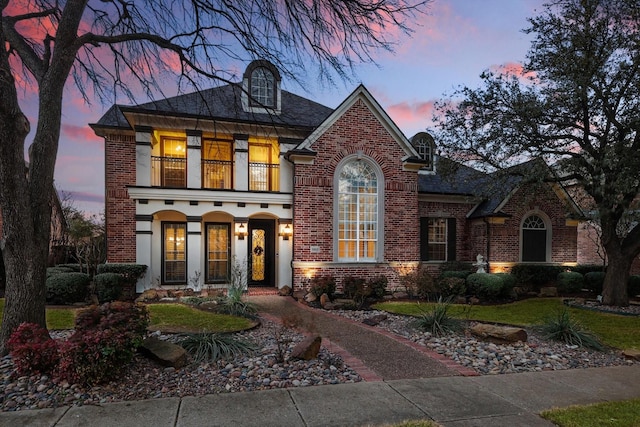 view of front of home with brick siding and a balcony