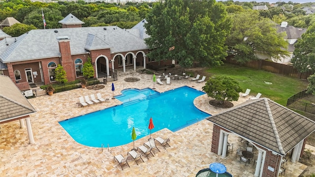 pool with a patio area, a lawn, an outdoor fire pit, and a fenced backyard