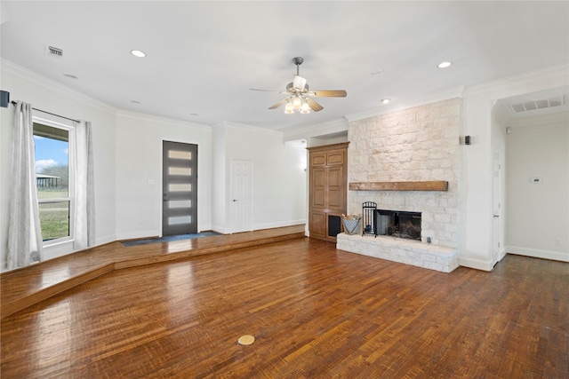 unfurnished living room with a fireplace, visible vents, dark wood-type flooring, and ornamental molding