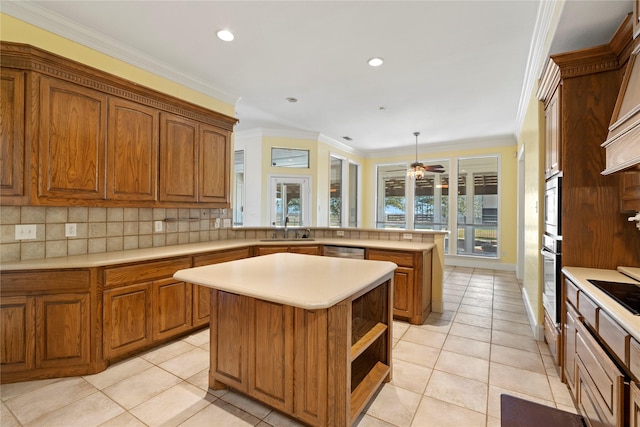 kitchen featuring ornamental molding, a center island, hanging light fixtures, light countertops, and backsplash