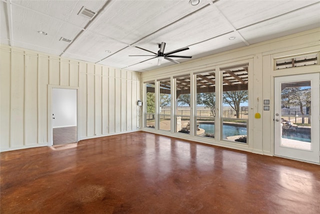 spare room with a healthy amount of sunlight, ceiling fan, finished concrete floors, and visible vents