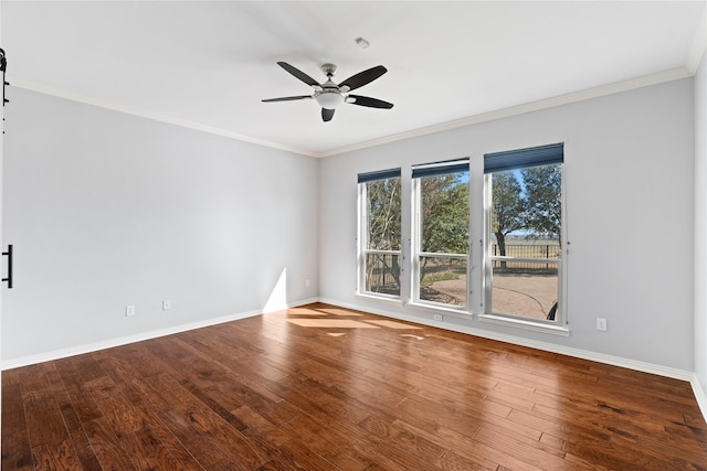 empty room with crown molding, wood-type flooring, a ceiling fan, and baseboards