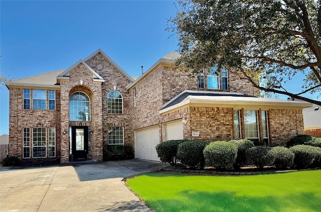 traditional-style house with a garage, brick siding, and driveway