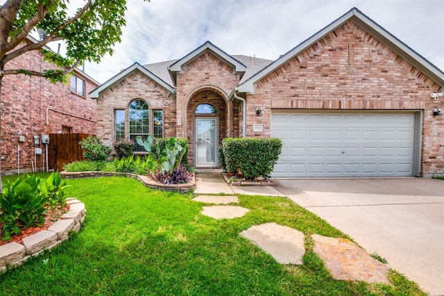 view of front of home featuring a front yard, concrete driveway, brick siding, and an attached garage