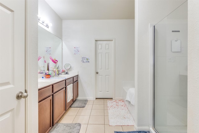 bathroom featuring double vanity, a stall shower, tile patterned flooring, and a sink