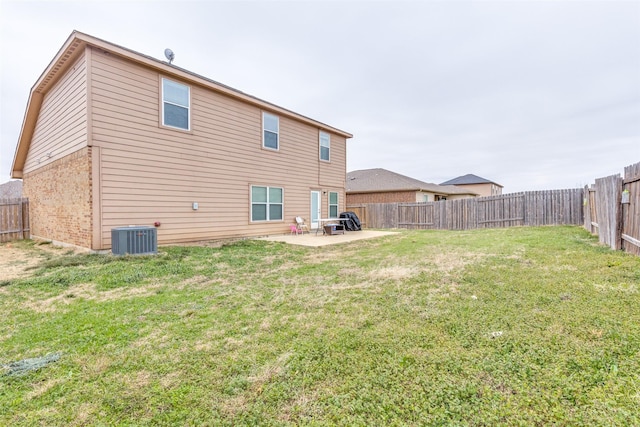 rear view of property featuring a lawn, a fenced backyard, central air condition unit, a patio area, and brick siding