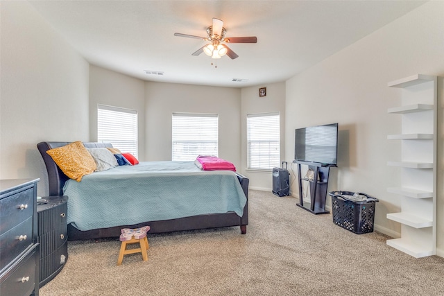 bedroom featuring a ceiling fan, light colored carpet, visible vents, and baseboards