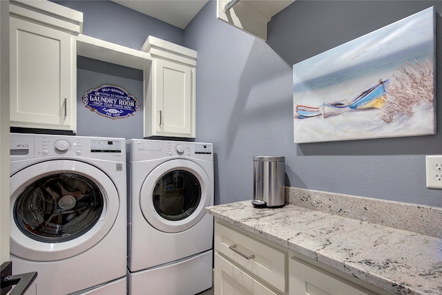 clothes washing area featuring cabinet space and independent washer and dryer