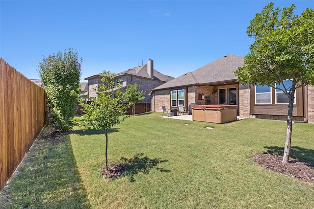 view of yard with a patio area, a fenced backyard, and a hot tub