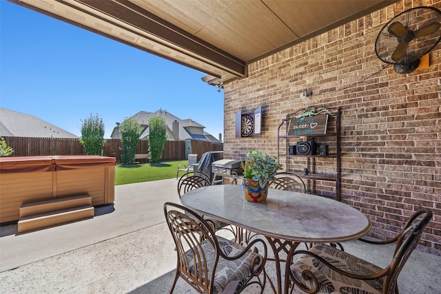 view of patio / terrace with outdoor dining space, a fenced backyard, ceiling fan, and a hot tub