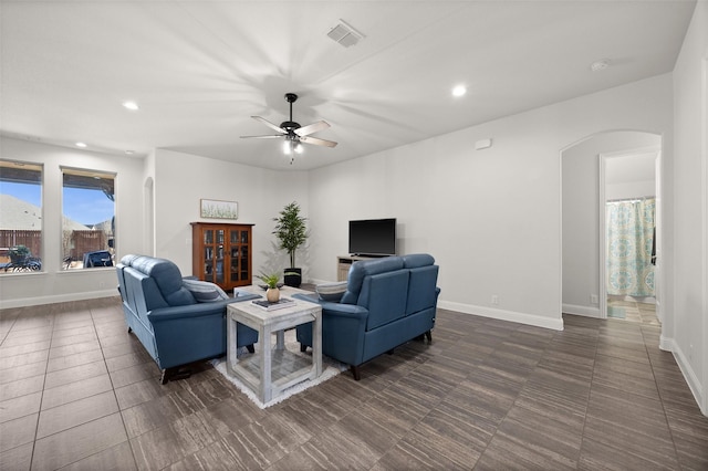 living room featuring visible vents, arched walkways, baseboards, and recessed lighting