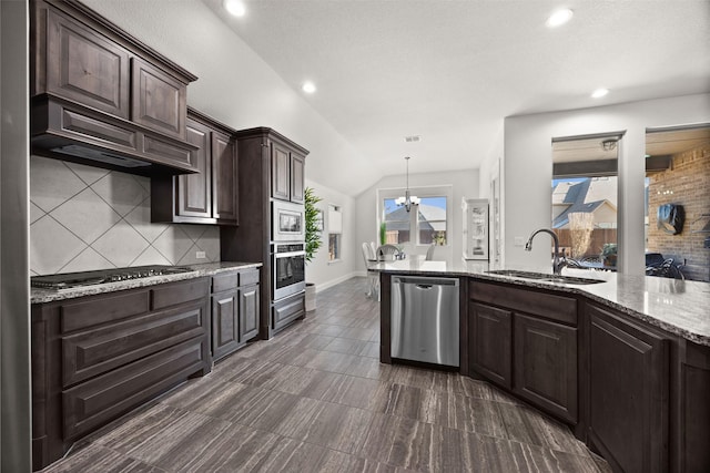 kitchen featuring lofted ceiling, dark brown cabinetry, a sink, appliances with stainless steel finishes, and tasteful backsplash