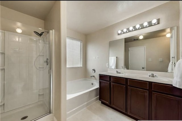 bathroom with double vanity, a stall shower, a garden tub, and a sink