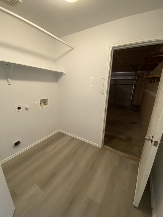 laundry area with laundry area, baseboards, wood finished floors, hookup for a washing machine, and electric dryer hookup