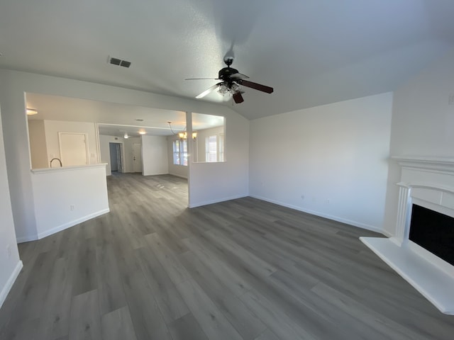 unfurnished living room featuring a fireplace with raised hearth, dark wood finished floors, and baseboards