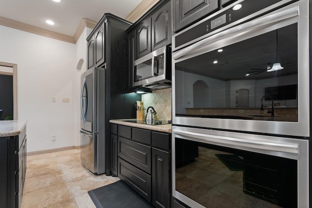 kitchen featuring dark cabinets, appliances with stainless steel finishes, backsplash, and ornamental molding