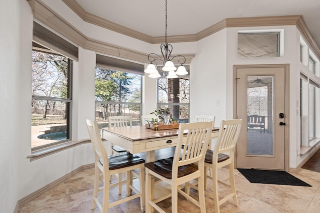 dining area featuring an inviting chandelier, baseboards, and ornamental molding