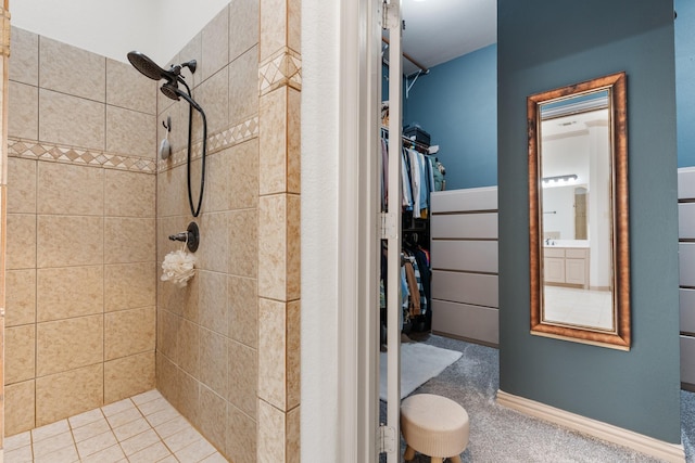 bathroom with a walk in closet and a tile shower