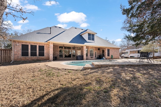 back of property featuring a patio, brick siding, fence, and a fenced in pool