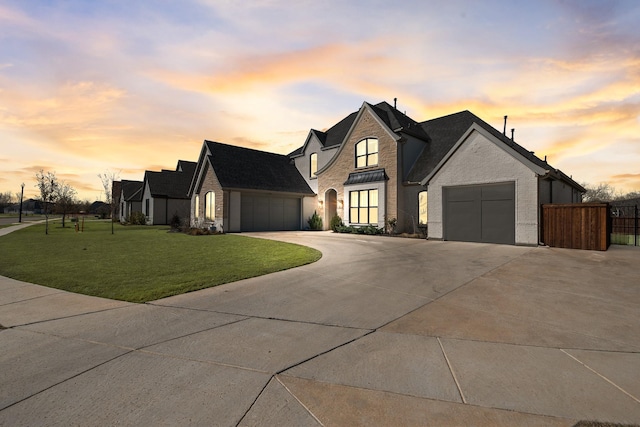 view of front of home with an attached garage, concrete driveway, brick siding, and a front yard