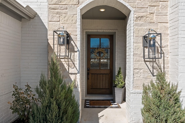 doorway to property featuring brick siding